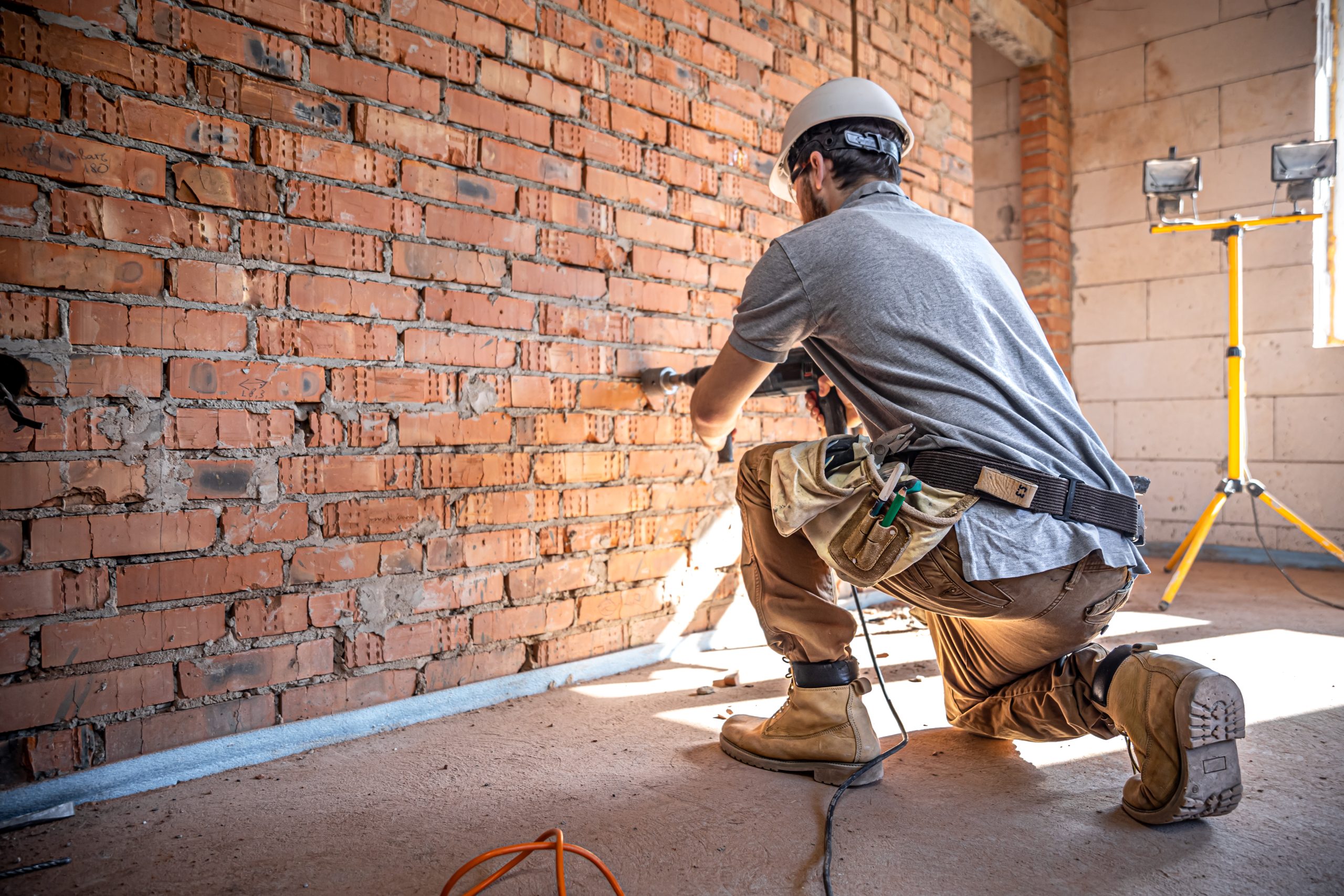 manitas en un sitio de construccion en el proceso de perforacion de una pared con un perforador scaled
